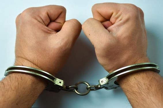 ہاتھوں میں ہتھکڑیاں ٹیبل پر رکھی ہیں۔