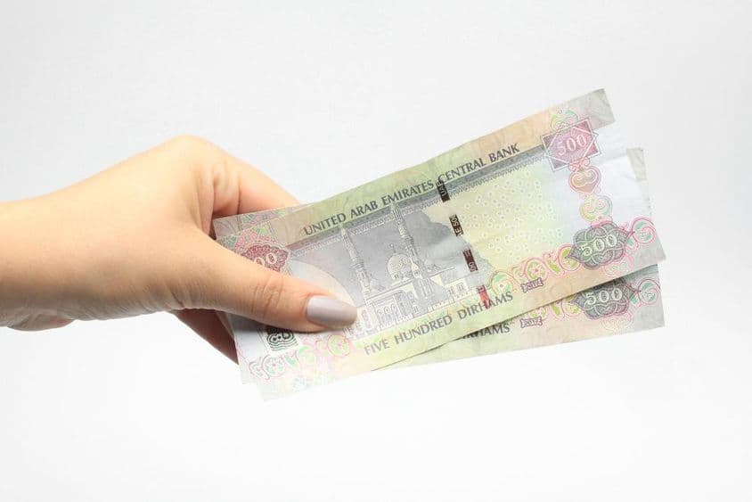 ایک عورت کے ہاتھ میں ٥٠٠ اے ای ڈی کرنسی۔