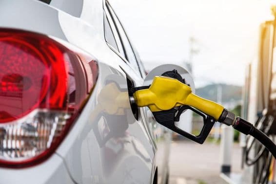 دبئی میں ایک آدمی گاڑی میں پیٹرول پمپ کر رہا ہے۔