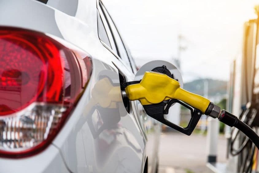 دبئی میں ایک آدمی گاڑی میں پیٹرول پمپ کر رہا ہے۔