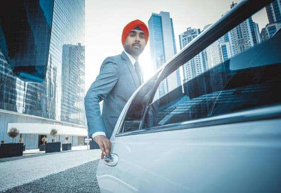 دبئی میں کمپنی کار کے ساتھ بھارتی بزنس مین۔
