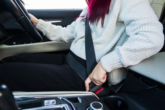 خاتون ڈرائیور اپنی سیٹ بیلٹ باندھ رہی ہیں۔