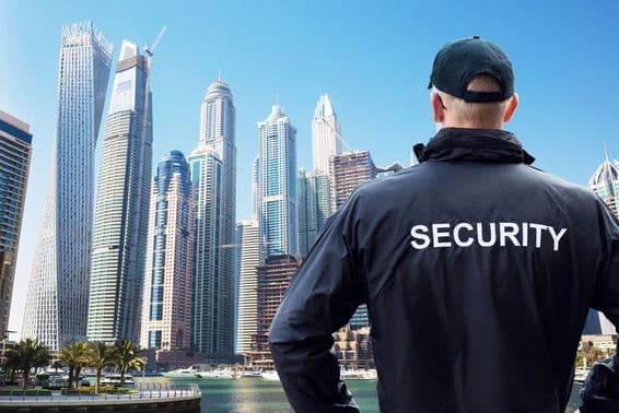 ایک مرد سکیورٹی گارڈ پیچھے سے شہر کے منظر کو دیکھ رہا ہے۔