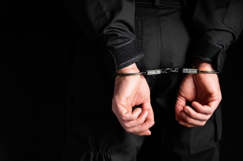 ایک مجرم کے ہاتھ ہتھکڑیوں میں۔