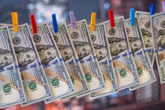 لکڑی کے کلپ کے ساتھ کپڑے کی لائن پر لٹکا ہوا ۱۰۰ امریکی ڈالر کا بل۔