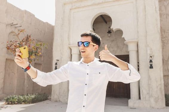 ایک آدمی پرانے بر دبئی کریک ضلع میں ویڈیو بلاگ ریکارڈ کر رہا ہے۔