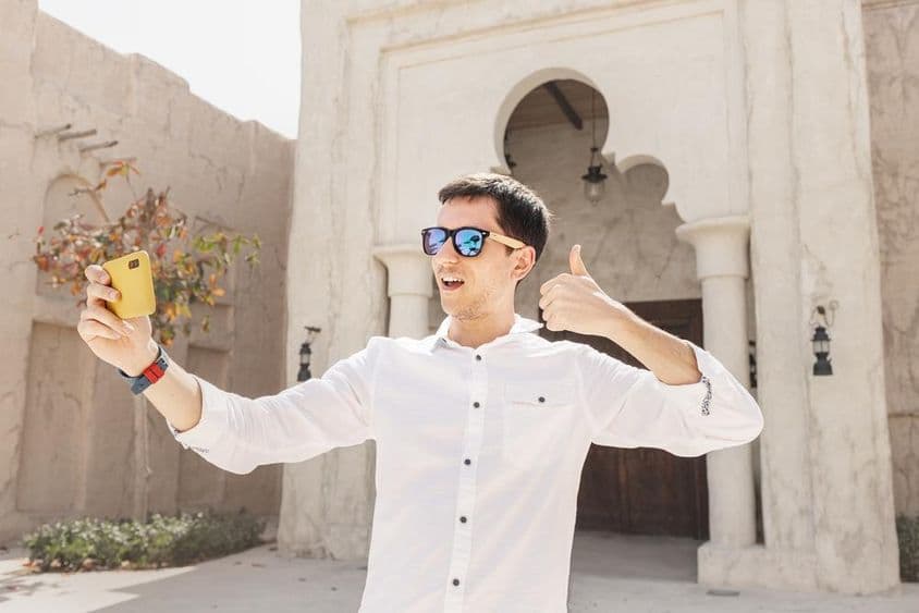 ایک آدمی پرانے بر دبئی کریک ضلع میں ویڈیو بلاگ ریکارڈ کر رہا ہے۔