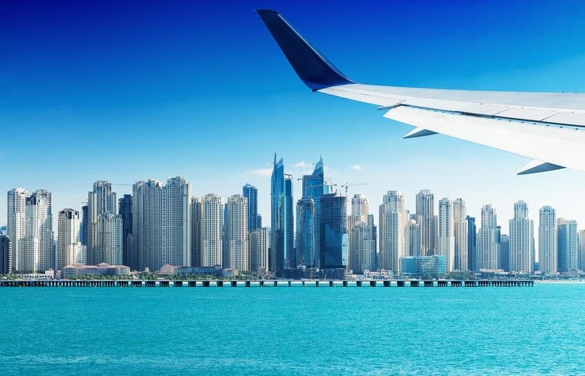 دبئی کی عمارتوں کے اوپر سے گزرتا جہاز۔