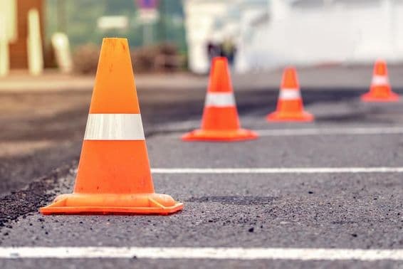اسفالٹ روڈ پر نارنجی کن کے قطاریں۔