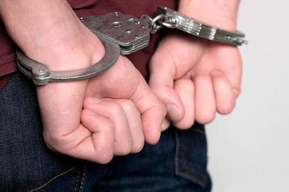 ایک مجرم گرفتار اور ہتھکڑی لگا ہوا ہے۔