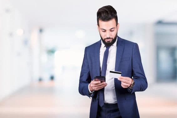 عرب کاروباری فرد سمارٹ فون اور کریڈٹ کارڈ ہاتھ میں لیے ہوئے