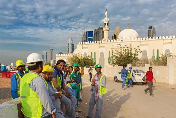 جدید دبئی کے مرکز میں ایک مسجد کے قریب آرام کرتے ہوئے تعمیراتی کارکن۔