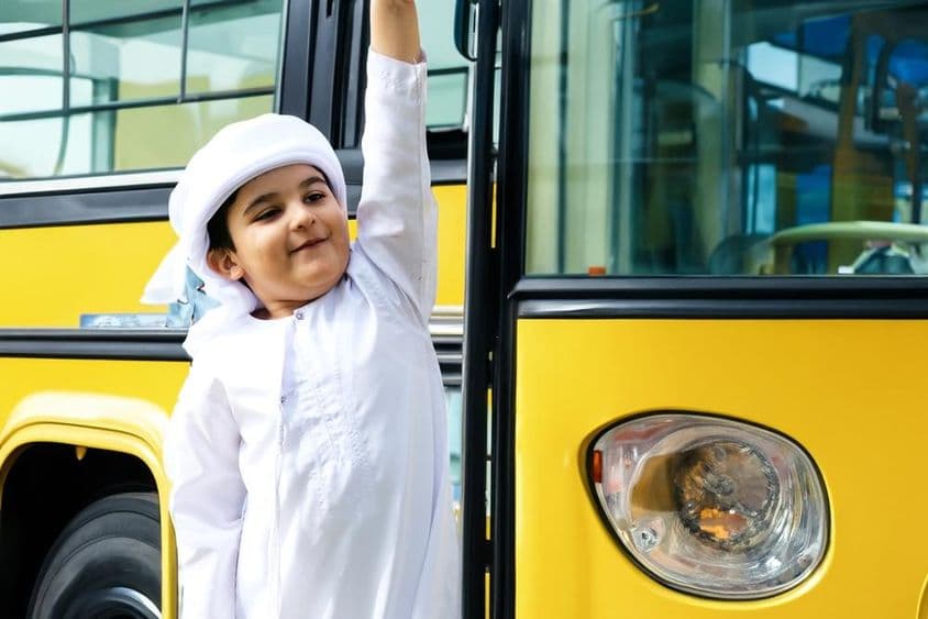 عرب ایلیمنٹری اسکول کے طالب علم پیلے اسکول بس کے قریب