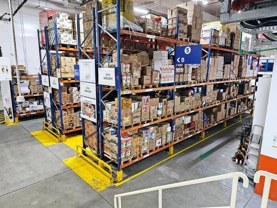 شیلفنگ سسٹم کے ساتھ ویئرہاؤس، لیبل شدہ مصنوعات کی کیٹیگریز، اور محفوظ کارکردگی کو بہتر بنانے والے حفاظتی نشانیاں۔