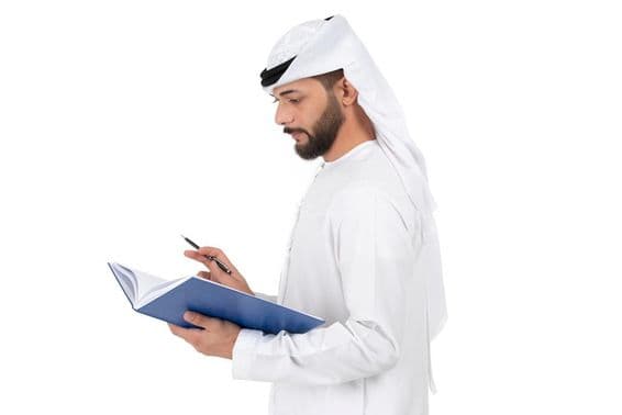 ایک جوان عرب استاد کتاب میں لکھتے ہوئے۔