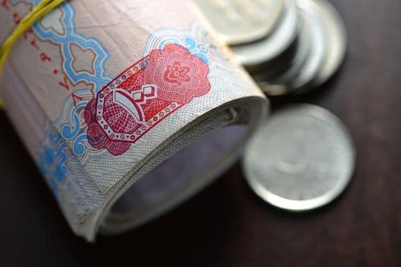 رولڈ اپ یو اے ای درہم کے ساتھ چند سکے۔