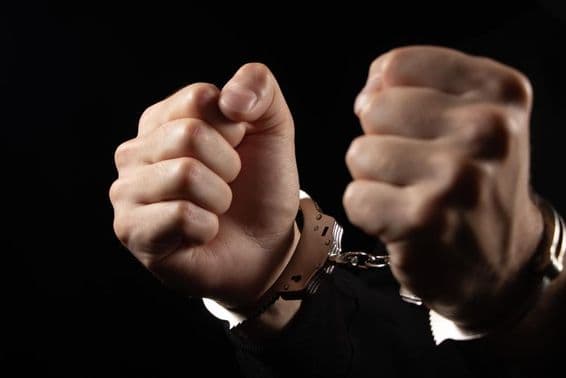 جرائم کے لیے گرفتار مرد، ہتھکڑیا لگا ہوا۔