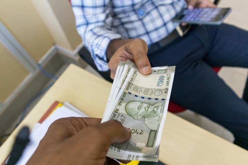 ایک شخص دوسرے شخص کو ۵۰۰ روپیہ کا ہندوستانی نوٹ دے رہا ہے۔