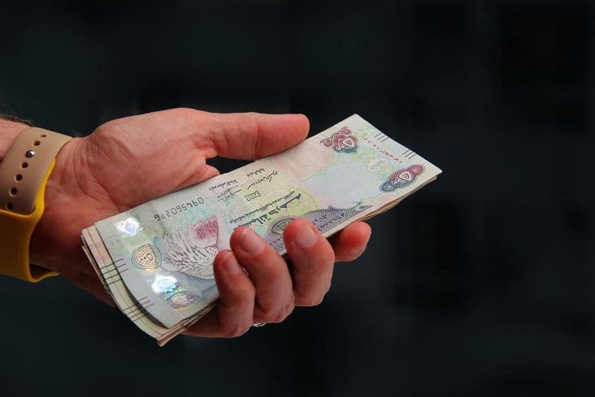 متحدہ عرب امارات، دبئی درہم ایک آدمی کے ہاتھ میں۔