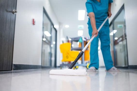 صفائی والا دالان کے فرش کو صاف کر رہا ہے۔