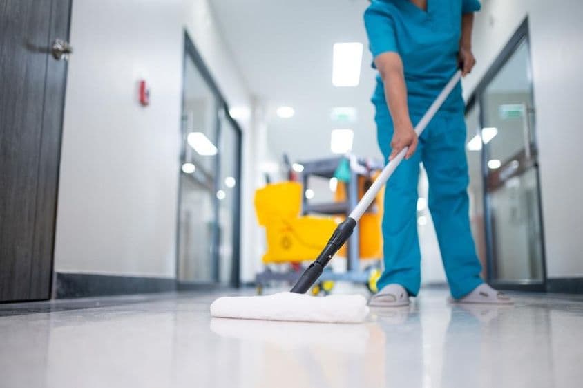 صفائی والا دالان کے فرش کو صاف کر رہا ہے۔