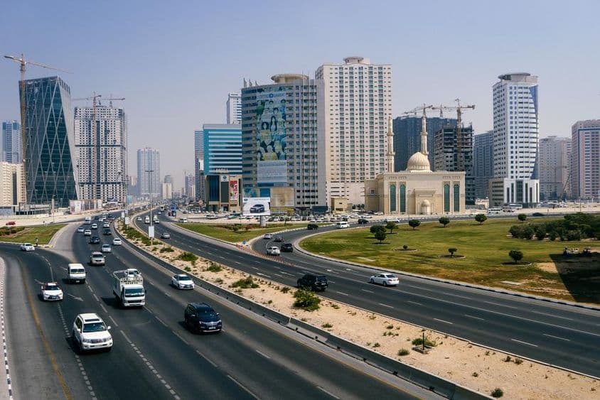 شہر اور شاہراہ کا منظر، پل کی بلندی سے کئی گاڑیاں۔