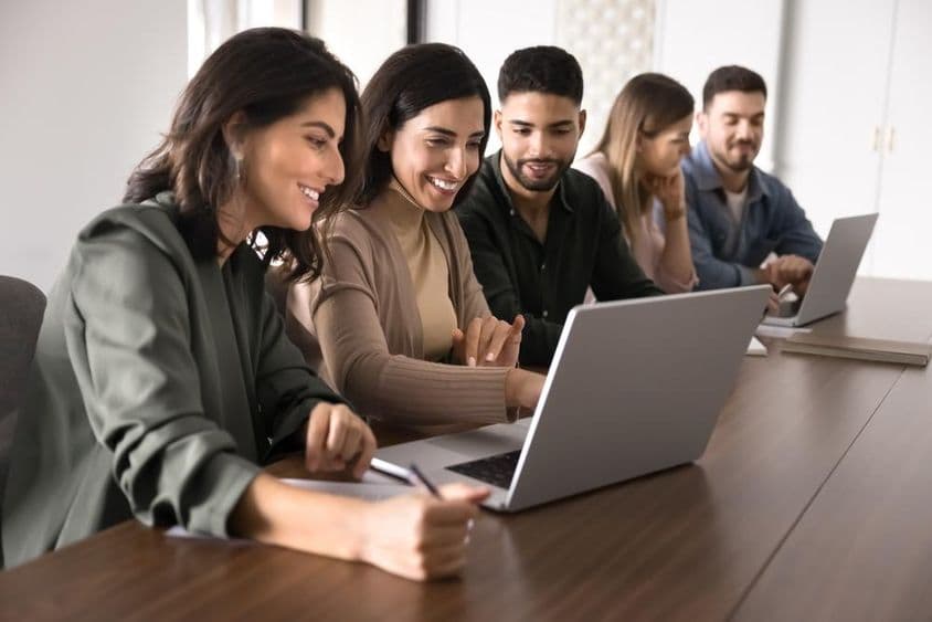 ایک تعلیمی مرکز میں لیپ ٹاپ پر مطالعہ کرتے ہوئے مختلف قومیت کے بالغ طلباء۔