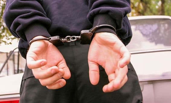 ایک شخص، جس کے ہاتھ پیچھے کف لگی ہوئی ہیں۔