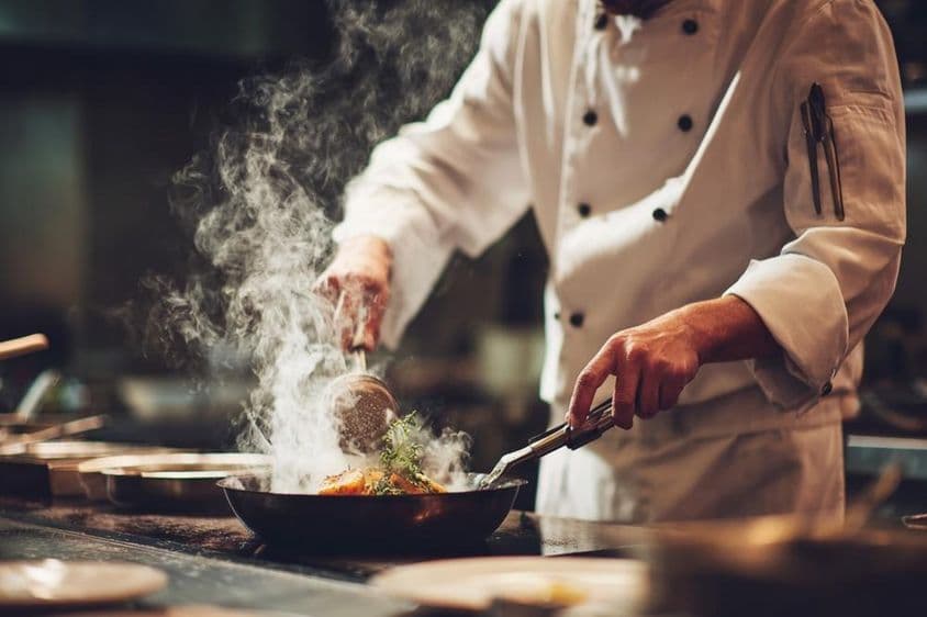 باورچی باورچی خانے میں کھانا پکاتے ہوئے۔