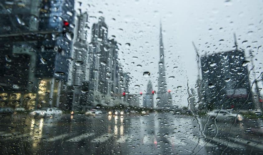 دبئی میں بارش، پس منظر میں شہر کے مناظر دھندلے نظر آ رہے ہیں۔