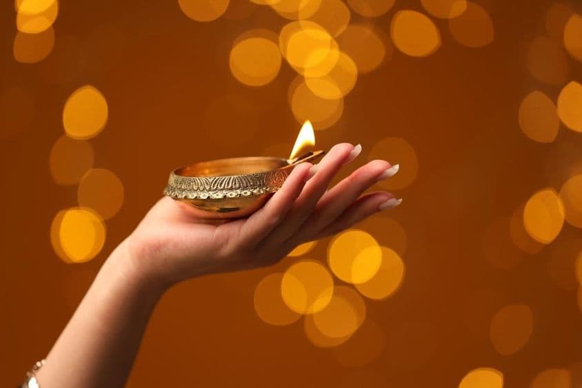 دیوالی کا چراغ روشن کرتی خاتون