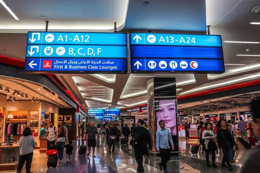 مسافر دبئی انٹرنیشنل ایئرپورٹ پر بورڈنگ گیٹس کی طرف جاتے ہوئے