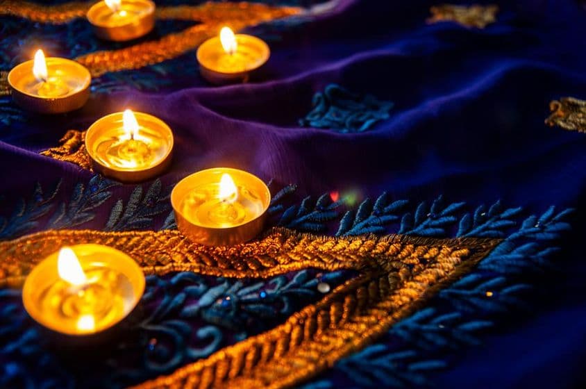نیلے ساڑی پر سونے کی کڑھائی سے کیا گیا دیوالی کا روشن چراغ