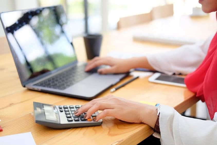 خاتون مالیات کے ساتھ کام کرتی ہوئی اور ٹیکس کا حساب لگاتی ہوئی