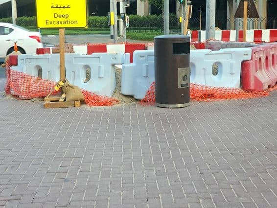 سڑک کی مرمت پلاسٹک کی رکاوٹوں اور نارنجی حفاظتی جال سے گھری ہوئی ہے۔