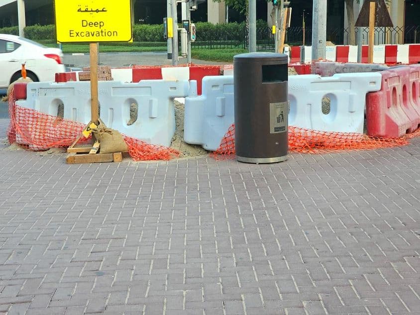 سڑک کی مرمت پلاسٹک کی رکاوٹوں اور نارنجی حفاظتی جال سے گھری ہوئی ہے۔