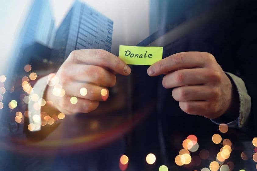 کاروباری شخصیت ایک دستاویز کے ساتھ 'عطیہ' کا لفظ دکھاتے ہوئے۔