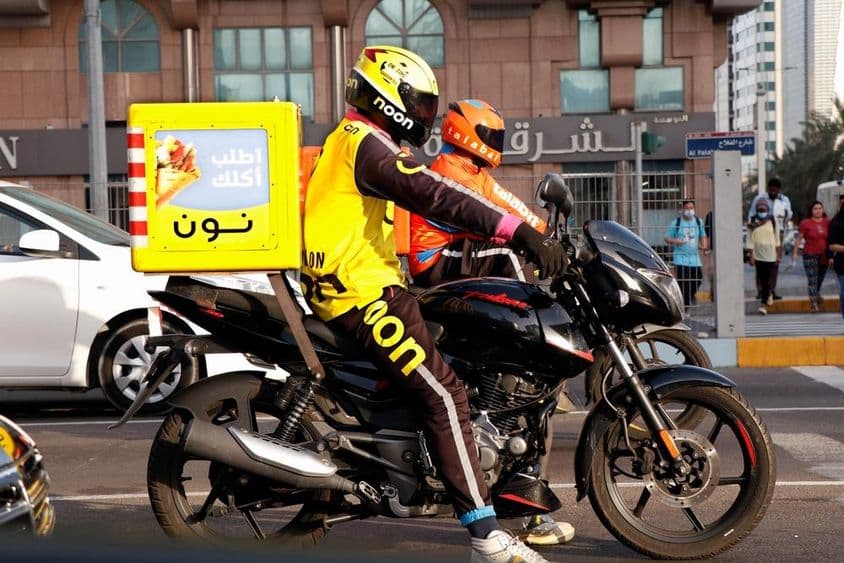 دبئی کی گلی میں موٹر سائیکل کورئیر ڈلیور کرتے ہوئے۔