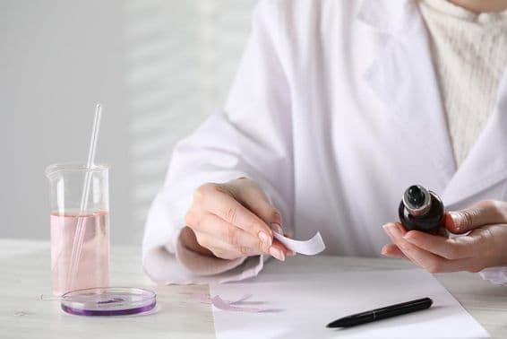 ایک سفید لکڑی کی میز پر لیبارٹری میں عیش و عشرت کا پرفیوم۔