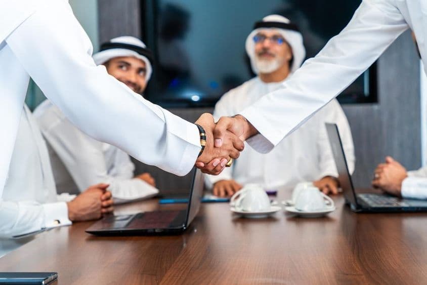 عرب کاروباری مرد اماراتی کندورا میں دبئی کی بورڈ روم میں کام کر رہے ہیں۔