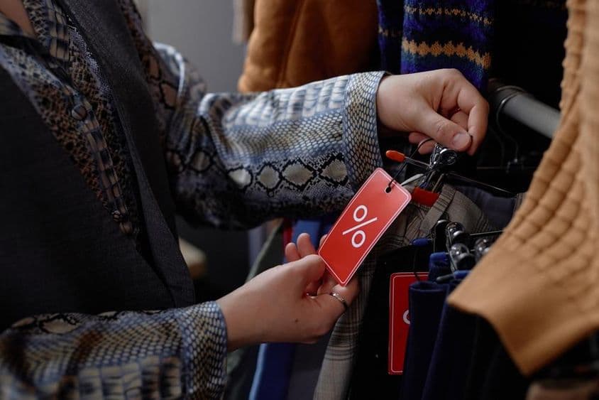 ایک خواتین جو وِنٹیج لباس میں قدیم کپڑے چن رہی ہیں۔