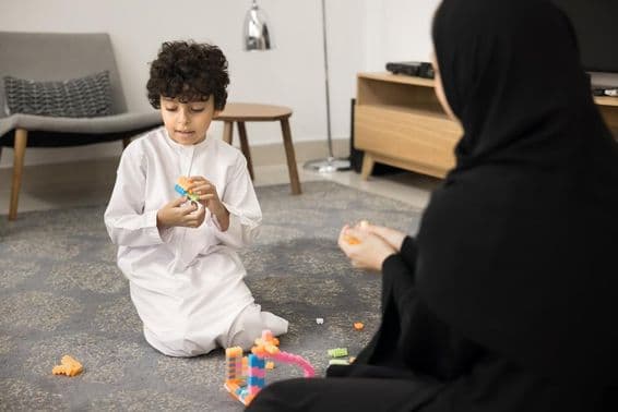 ایک نوجوان عرب عورت تخلیقی کھلونوں کے ساتھ ایک مسلم گھر میں تعلیم دیتے ہوئے۔