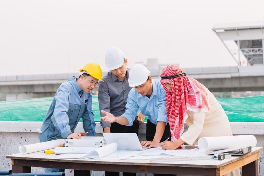 ایک عرب کاروباری آدمی، انجینئر، اور ورکر لیپ ٹاپ کا استعمال کرتے ہوئے تعمیراتی منصوبوں کے ساتھ مشغول ہیں۔