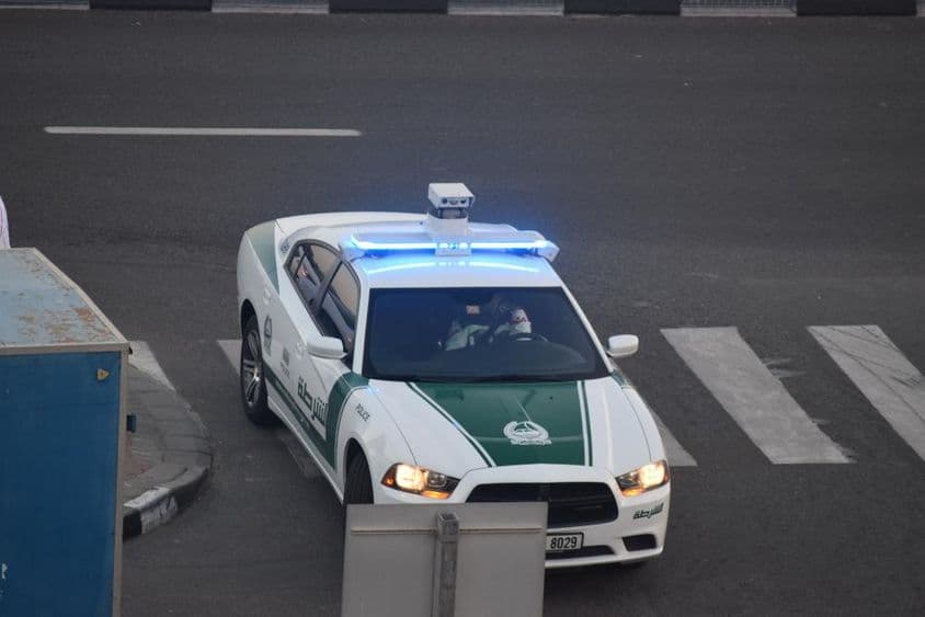 ایک دبئی پولیس کی گاڑی سڑک پر چل رہی ہے۔