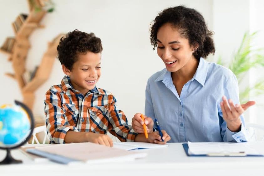 ایک خاتون استاد ایک بچے کو سبق سمجھا رہی ہیں۔