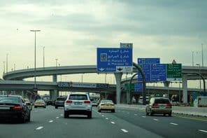 دبئی کی سڑک گاڑیوں اور اوور پاس کے اشتہار کے ساتھ۔