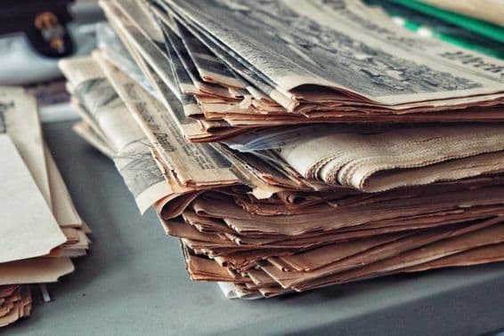 پرانے اخبار مکڑی کے جال کے ساتھ جمع شدہ۔