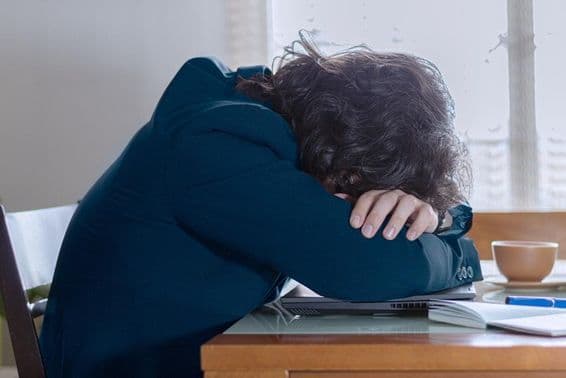 پیر کے دن دفتر میں لیپ ٹاپ پر آرام کرتا ہوا شخص۔