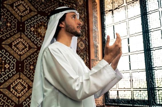 مسجد میں دعا کر رہا ایک نوجوان شخص۔