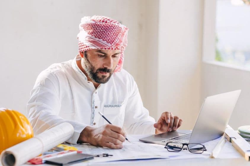 عرب سول انجینئر ایک منصوبہ نقشہ کے ساتھ کام کرتے ہوئے۔